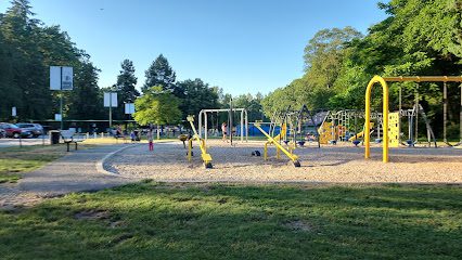 ![A park with a playground and trees in the background.