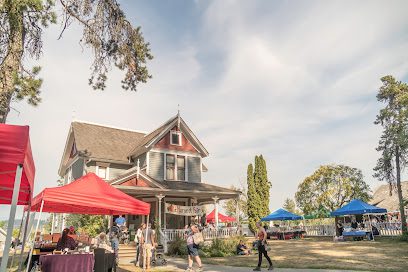 ![A group of people at a market in front of a house.