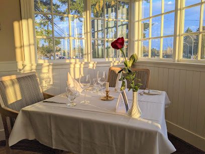 ![A table with a rose on it in front of a window.