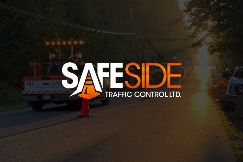 A tow truck from Safe Side Traffic Control Ltd. on a road at sunset, with traffic cones and a bright sunlight in the background.