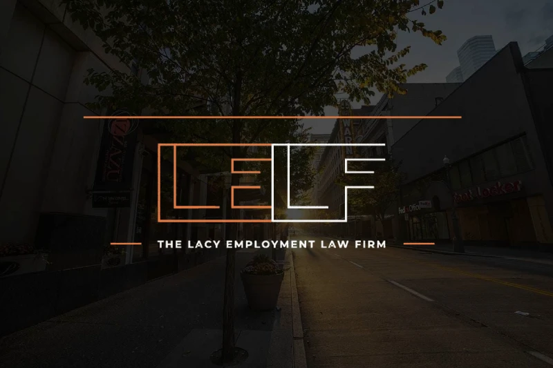 Logo of The Lacy Employment Law Firm superimposed over an image of a quiet city street at twilight.
